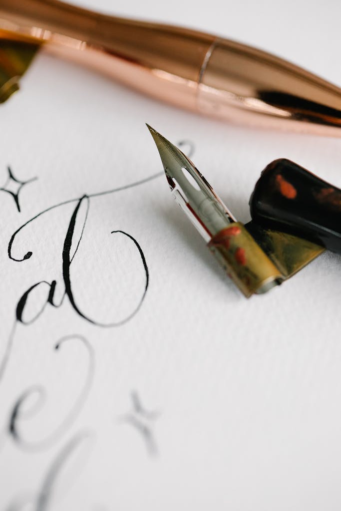 Close-up of artistic calligraphy with a fountain pen on white textured paper.